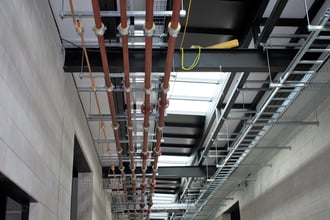 cable and pipe run supported by trapeze brackets